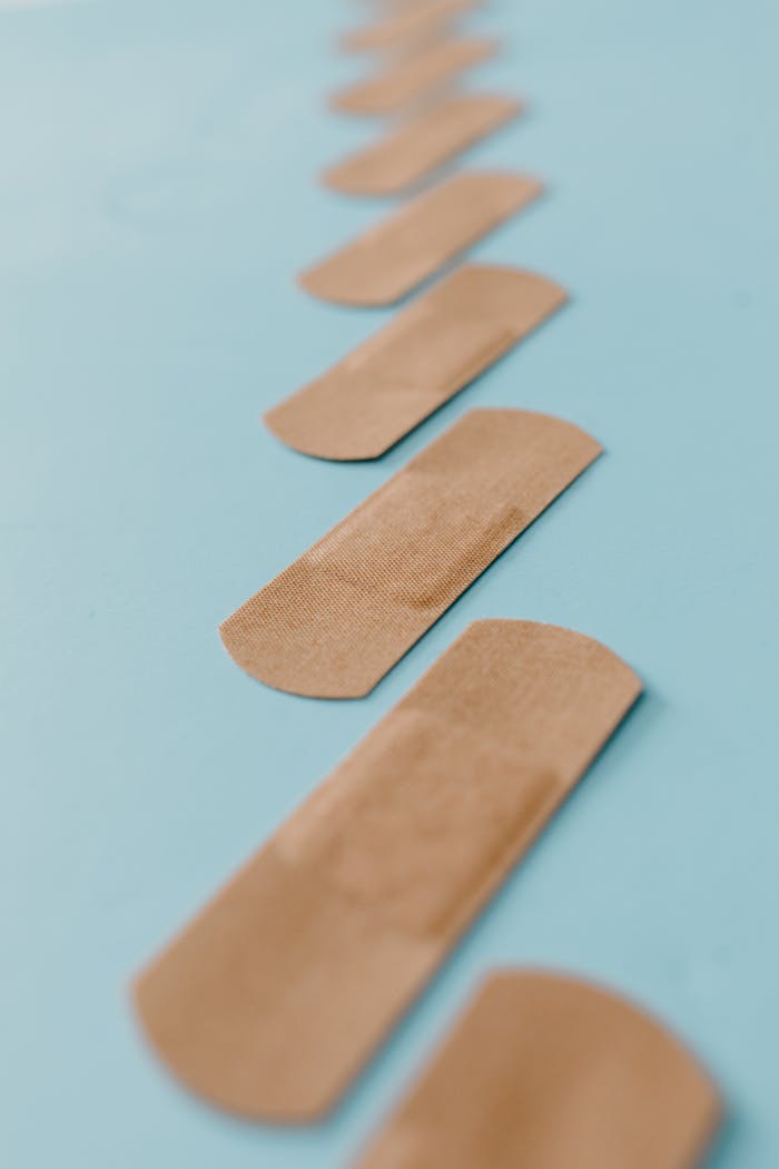 An artistic shot of band-aids arranged on a light blue background, showcasing simplicity and healthcare themes.